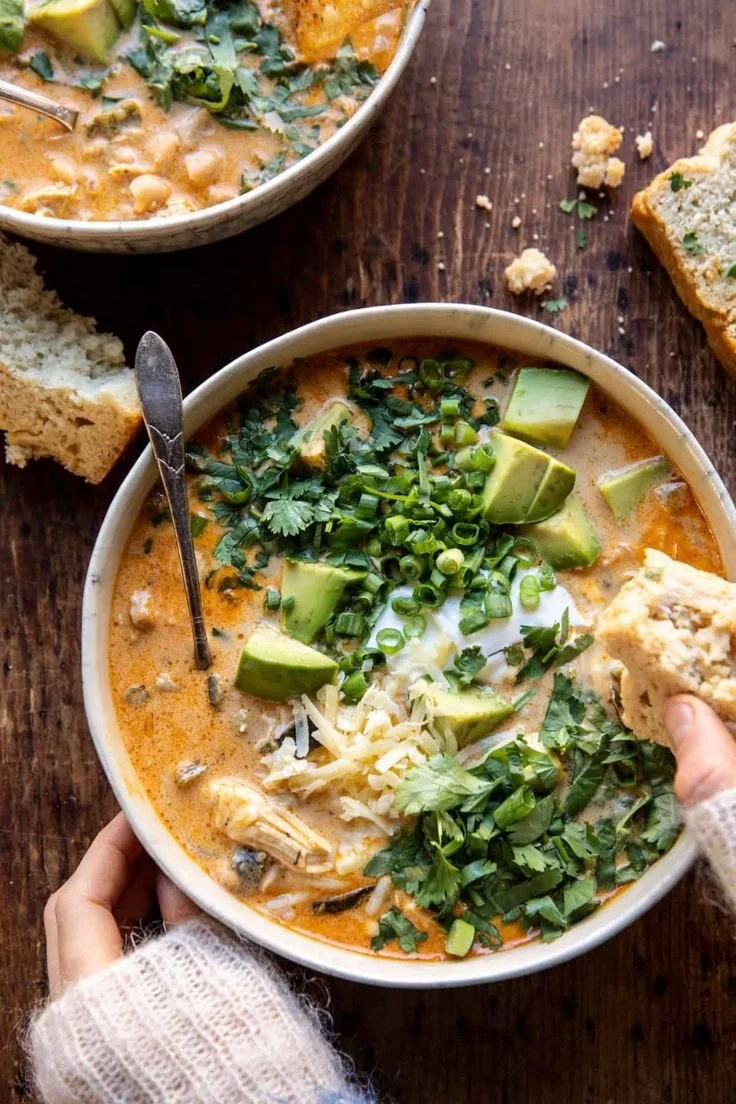 Bowl of creamy white chicken chili topped with cilantro and tortilla strips