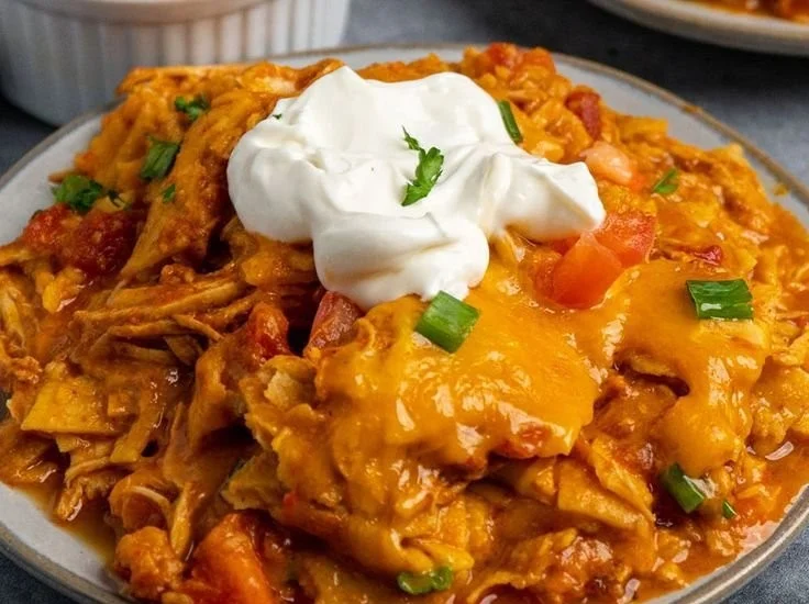 Crock Pot Chicken Enchilada Casserole topped with cheese and garnished with cilantro