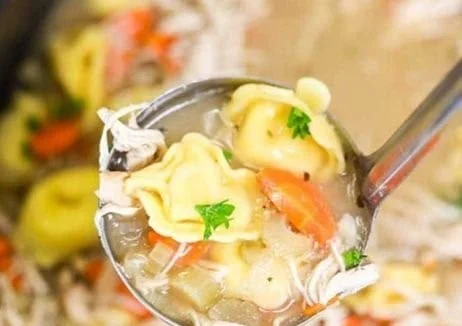 Bowl of delicious Crock Pot Chicken Tortellini Soup with fresh ingredients