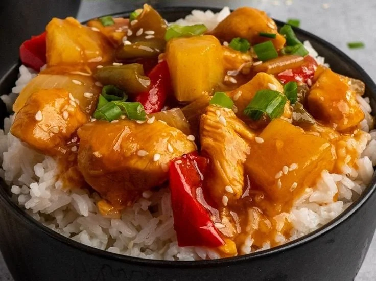 Crock-Pot sweet and sour chicken served on a plate with colorful vegetables.