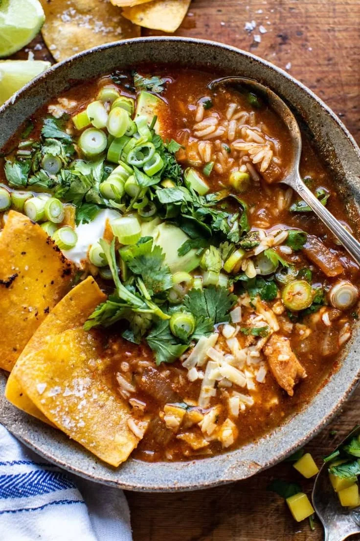 Crockpot Spicy Chicken Tortilla Soup served in a bowl with tortilla strips and toppings.
