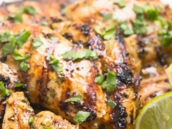 Plate of easy cilantro lime chicken garnished with lime and fresh cilantro.