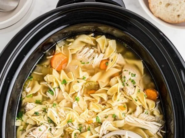 Bowl of easy slow cooker chicken noodle soup filled with noodles, chicken, and vegetables