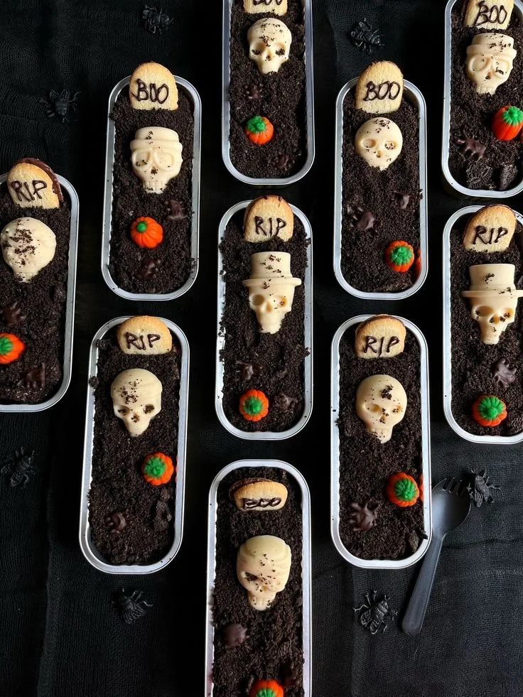 Delicious Graveyard Dirt Cups decorated for Halloween with gummy worms and cookie crumbles.