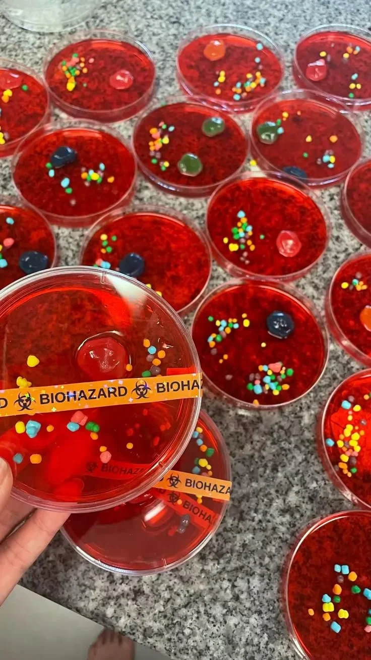 Spooky Halloween JellO shots in biohazard Petri dishes for a themed party.