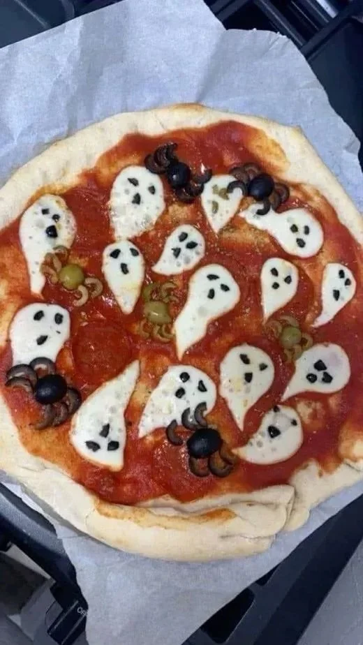 A spooky pizza decorated with creepy toppings for Halloween.